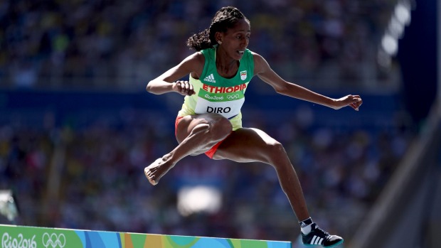 Etenesh Diro jumps a hurdle with one shoe