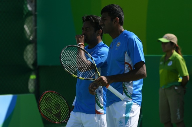 India's Leander Paes speaks to teammate India's Rohan Bopanna during their men's first round doubles tennis match in Rio de Janeiro