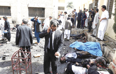 Pakistani lawyers and security officials gather around the bodies of victims of a bomb explosion at a government hospital premises in Quetta