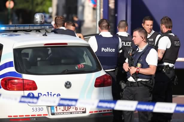 Police stand as they secure the area around a police building in the southern Belgian city