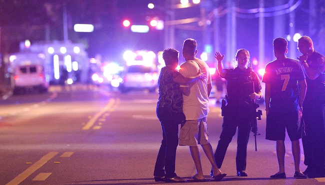 Orlando Police officers direct family members away from a fatal shooting at Pulse Orlando nightclub in Orlando Fla. Sunday