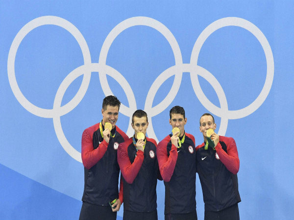 From right Caeleb Dressel Michael Phelps Ryan Held and Nathan Adrian celebrate in the medals ceremony after winning gold in the men's 4 x 100-meter freestyle relay