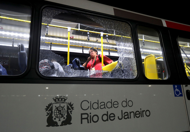 A member of the media stands near a shattered window on a bus in the Deodoro area of Rio de Janeiro Brazil at the 2016 Summer Olympics Tuesday Aug. 9 201