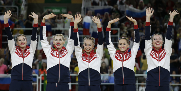 Team Russia wave from the podium before receiving their gold medals during the rhythmic gymnastics group all-around final at the 2016 Summer Olympics in Rio