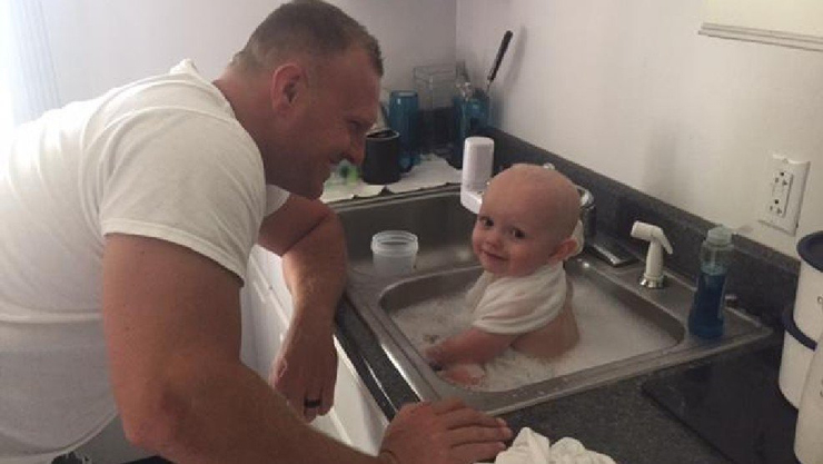 Trooper D.C. Graham of the West Virginia State Police bathes a baby found covered in vomit in the back seat of a car involved in a suspected DUI stop Tuesday