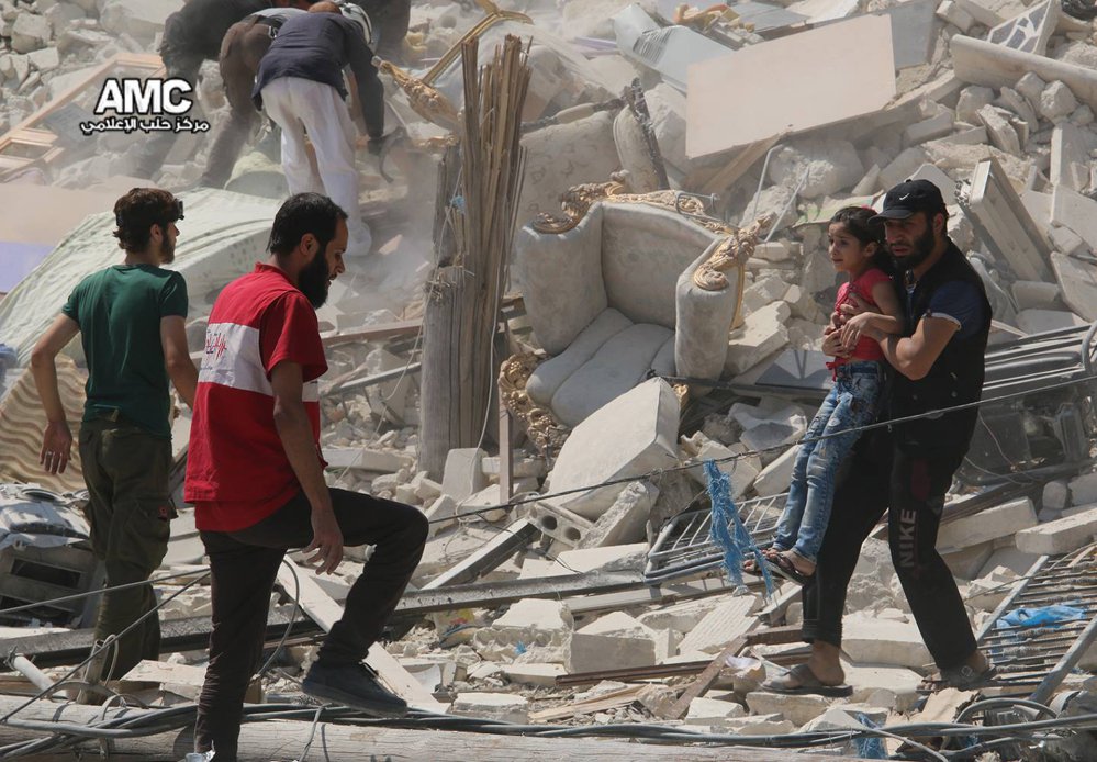 A Syrian man carries a girl away from a destroyed building after barrel bombs were dropped on Aleppo's Bab al Nairab neighborhood on Saturday