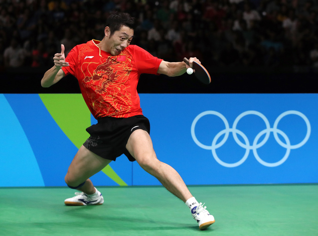 China's Xu Xin returns a shot to Japan's Jun Mizutani during the men's team table tennis gold medal competition at the 2016 Summer Olympics in Rio de Janeiro