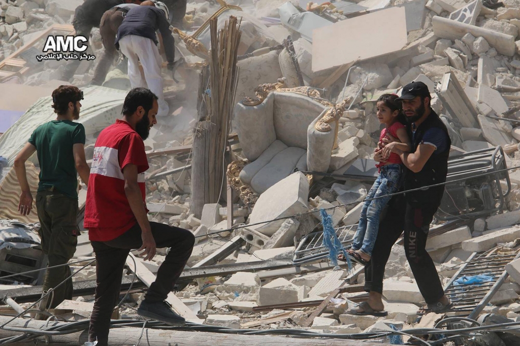 A Syrian man carries a girl away from the rubble of a destroyed building Saturday Aug. 27 2016 after barrel bombs were dropped on the Bab al Nairab neighborhood in Aleppo Syria. Syria activists said at least 15 civilians have been killed when suspec