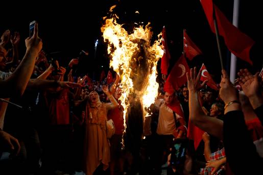 Supporters of Turkish President Tayyip Erdogan shout slogans over a burning effigy of US-based cleric Fethullah Gulen during a pro-government demonstration at Taksim Square in Istanbul Turkey on Wednesday night