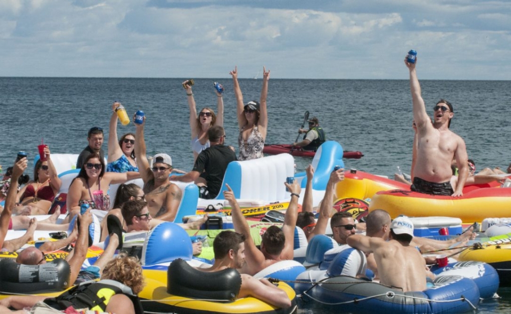 People celebrate as they start the Float Down at Lighthouse Beach in Port Huron Mich