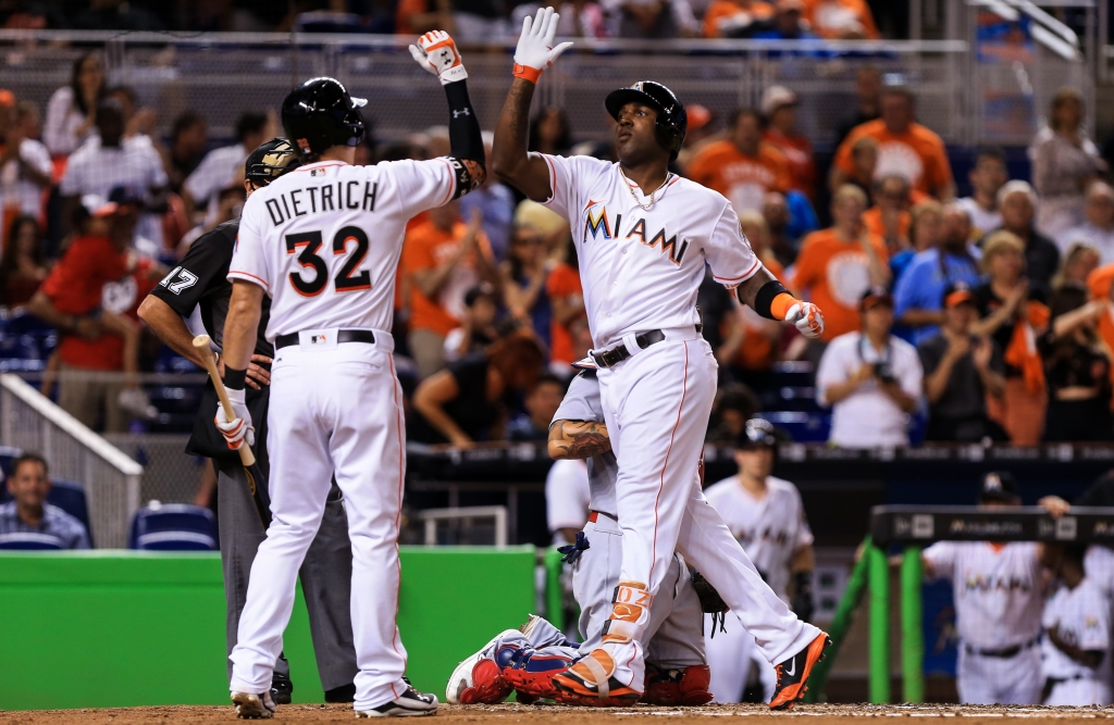 Marcell Ozuna #13 of the Miami Marlins slaps hands with Derek Dietrich #32 after hitting a home run during the second inning of the game against the St. Louis Cardinals at Marlins Park