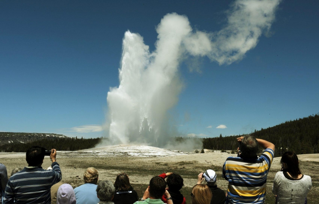 Tourists watch the'Old Faithful geyser which erupts on average every 90 minutes at Yellowstone National Park in Wyoming