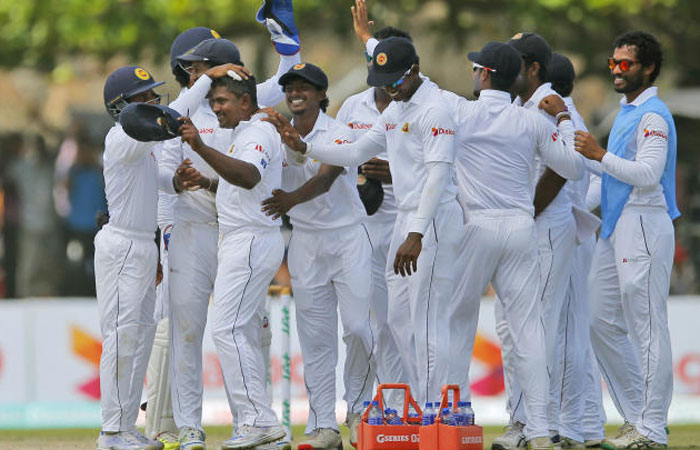 Members of Sri Lankan team congratulate bowler Rangana Herath for taking a hat trick dismissing Australia’s Mitchell Starc on day two of their second Test match in Galle Sri Lanka Friday. — AP