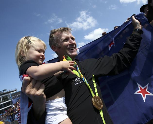 Gold medalist Mahe Drysdale of New Zealand celebrates with his daughter Bronte at Lagoa Stadium