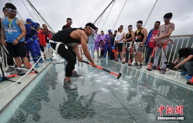 A man smashes the glass bridge over Zhangjiajie Grand Canyon with a 5.5-kilogram hammer in central China's Hunan Province