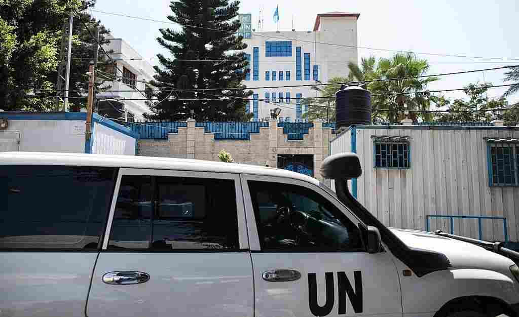 Palestinian staff of the United Nations Development Programme drive an official car in front of its headquarters in Gaza City on Tuesday