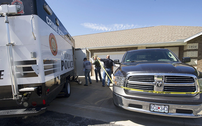 Joplin Police investigators survey the scene Saturday Aug. 13 2016 after an early morning shooting at the residence of shooting suspect Tom S. Mourning II 26