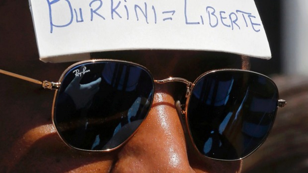 A man wears a sign with the message'Burkini = Liberty outside the Conseil d'Etat after France's highest