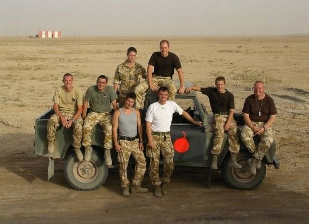 Butterworth stands on the back of a truck with his British armed forces comrades in Iraq