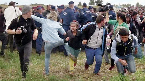 Camerawoman who tripped up refugees fleeing police charged in Hungary