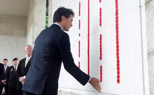 Canadian Prime Minister Justin Trudeau touches a memorial wall listing Canadian war dead after laying a wreath during a ceremony at the Sai Wan war cemetery in Hong Kong Tuesday Sept. 6 2016. The Sai Wan Bay Memorial includes the names of 228 Canadians