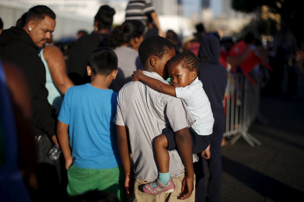 People wait in line at the Fred Jordan Mission annual back to school giveaway of shoes clothing and backpacks for more than 4,000 homeless and underprivileged children in Los Angeles California United States