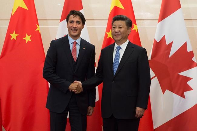 Chinese President Xi Jinping welcomes Canadian Prime Minister Justin Trudeau to the Diaoyutai State Guesthouse in Beijing Wednesday