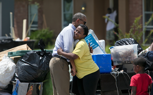 President Barack Obama hugs Marlene Sanders as he visits with with residents of Castle Place a flood-dama