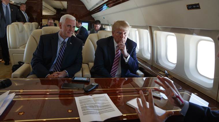 Republican presidential candidate Donald Trump talks with press Monday Sept. 5 2016 aboard his campaign plane while flying over Ohio as Vice presidential candidate Gov. Mike Pence R-Ind. left looks