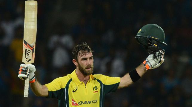 Australia’s Glenn Maxwell raises his bat and helmet in celebration after scoring a century during the first T20 international cricket match between Sri Lanka and Australia at the Pallekele International Cricket Stadium in Pallekele