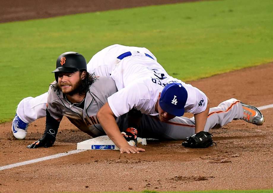 LOS ANGELES CA- SEPTEMBER 20 Brandon Crawford #35 of the San Francisco Giants reacts after he is tagged out at third base by Corey Seager #5 of the Los Angeles Dodgers to end the top of the second inning at Dodger Stadium