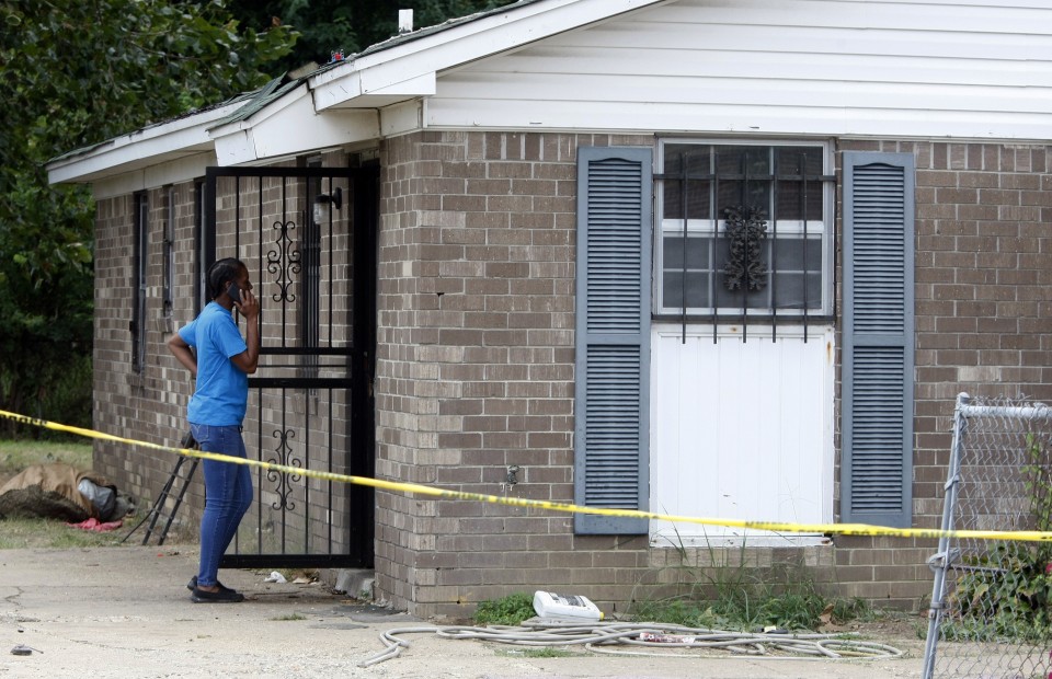 Janie Hendrix looks into a home where an early morning fire killed multiple people including children