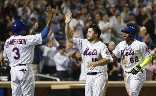 New York Mets Curtis Granderson greets Travis d'Arnaud and Yoenis Cespedes after all three scored on Kelly Johnson's eighth-inning double in a baseball game against the Miami Marlins Wednesday Aug. 31 2016 in New York. (AP