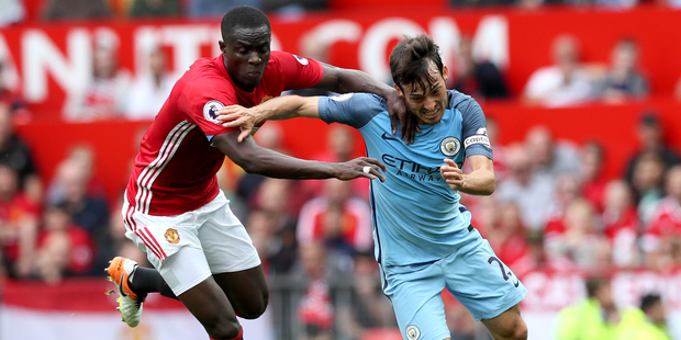 Manchester United's Eric Bailly left and Manchester City's David Silva battle for the ball during the English Premier League soccer match