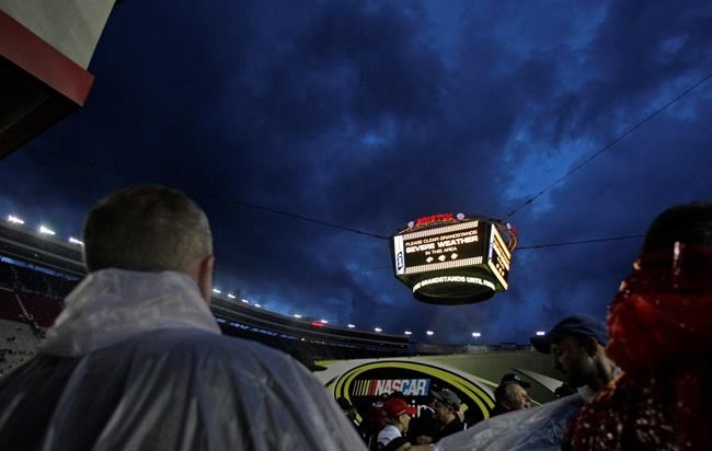 People look at the threatening sky as stormy weather delays the start of the NASCAR Sprint Cup Series auto race Saturday Aug. 20 2016,in Bristol Tenn