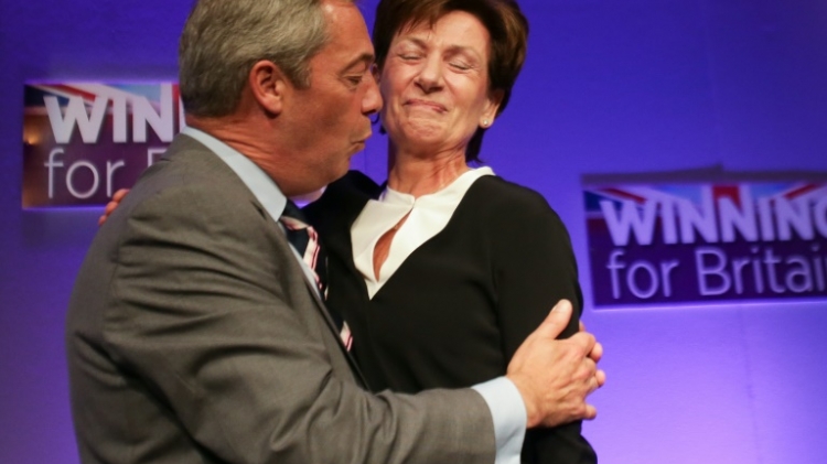 Outgoing UKIP leader Nigel Farage embraces the party's new leader Diane James as she is introduced at the UKIP Autumn Conference in Bournemouth on the southern coast of England