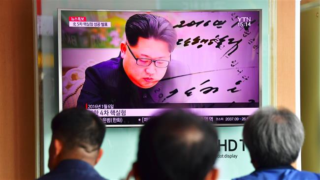 People watch a television news report showing file footage of North Korean leader Kim Jong-un at a railway station in Seoul