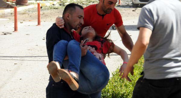 People carry a wounded person after the car bomb today. Pic AP