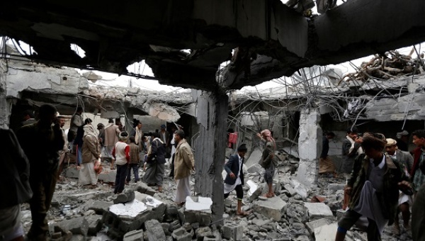 People gather at a building destroyed by Saudi-led air strikes in the northwestern city of Amran Yemen Sept. 8 2016