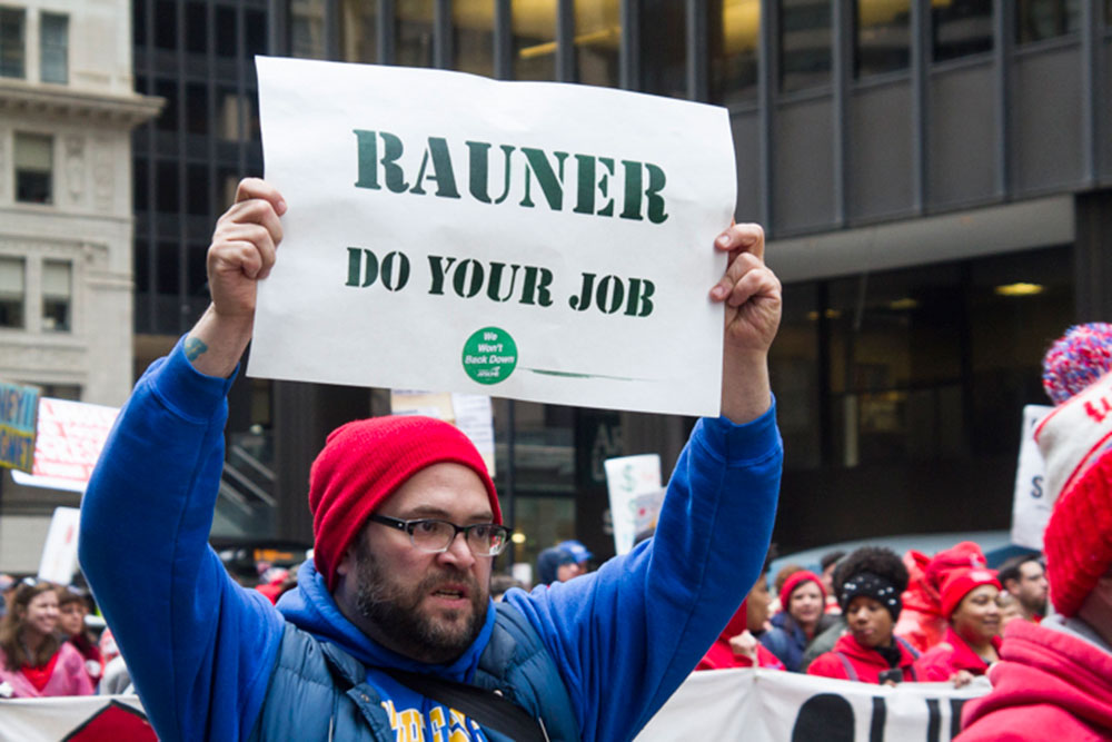 A demonstrator displays a sign at a march organized by the Chicago Teachers Union during their one-day strike