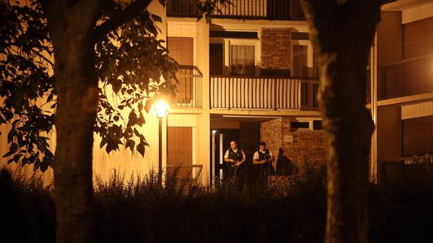 Police officers stand guard as they take part in a raid in Boussy-Saint-Antoine east of Paris