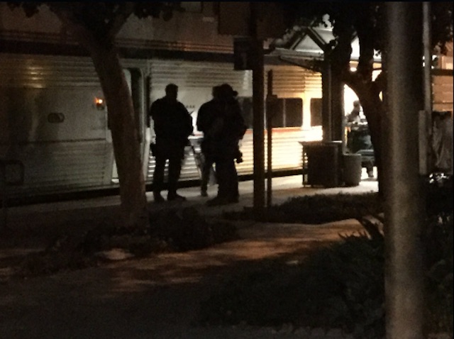 Police with assault rifles wait outside the stopped Amtrak train