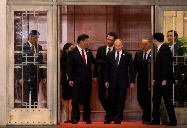 China's President Xi Jinping speaks to Russian counterpart Vladimir Putin as they walk across a garden prior to a dinner banquet at the G20 Summit