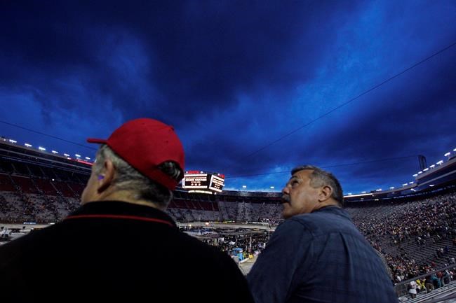 Mike Holbrook right and William Cantrell look to the sky as severe weather delayed the start of the NASCAR Sprint Cup Series auto race Saturday Aug. 20 2016 in Bristol Tenn