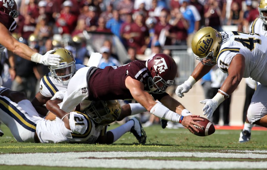 Associated Press Texas A&M quarterback Trevor Knight dives over the goal line for a touchdown as UCLA defensive back Tahaan Goodman attempts to tackle him during the third quarter of Saturday's game