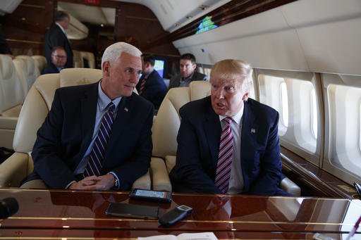 Republican presidential candidate Donald Trump talks with press Monday Sept. 5 2016 aboard his campaign plane while flying over Ohio as Vice presidential candidate Gov. Mike Pence R-Ind. left looks