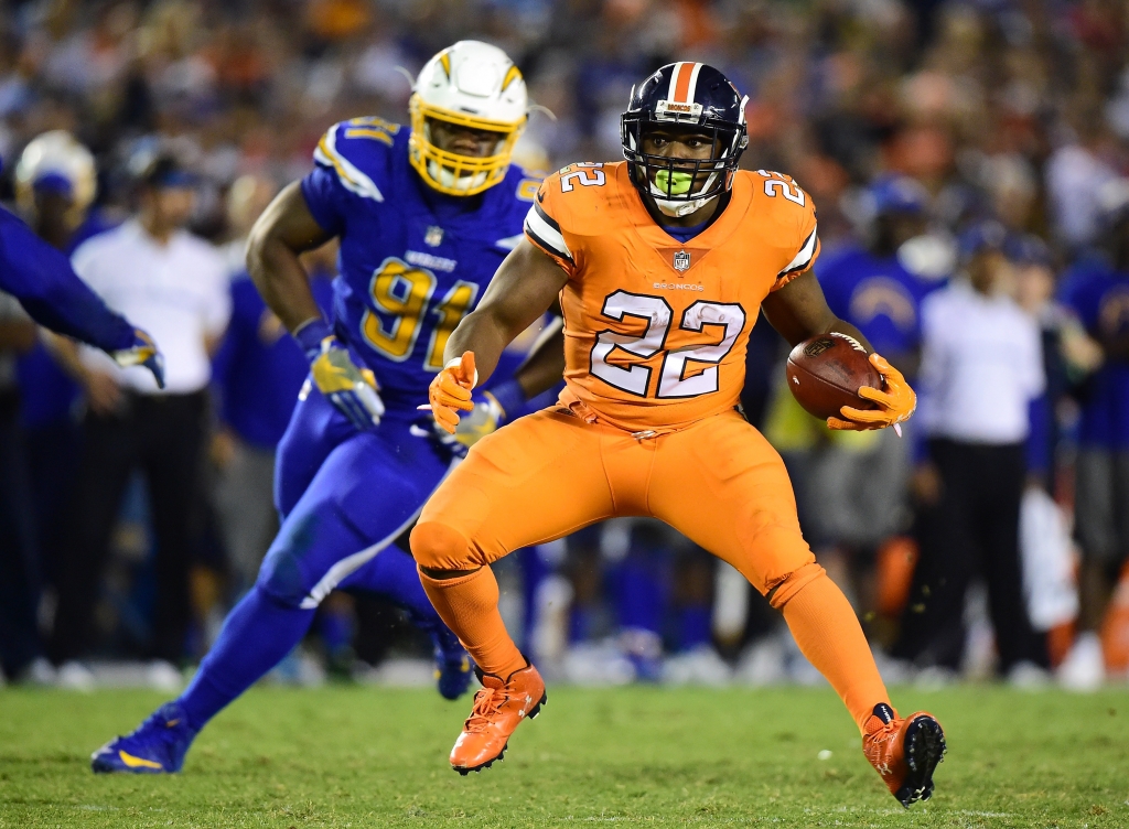 SAN DIEGO CA- OCTOBER 13 C.J. Anderson #22 of the Denver Broncos carries the ball as he is followed by Caraun Reid #91 of the San Diego Chargers during the fourth quarter of a 21-13 Charger win at Qualcomm Stadium