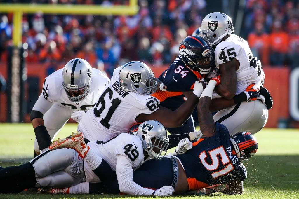 DENVER CO- DECEMBER 13 Fullback Marcel Reece #45 of the Oakland Raiders is stopped by linebacker Brandon Marshall #54 and middle linebacker Todd Davis #51 of the Denver Broncos int he first quarter of a game at Sports Authority Field at Mile High on D