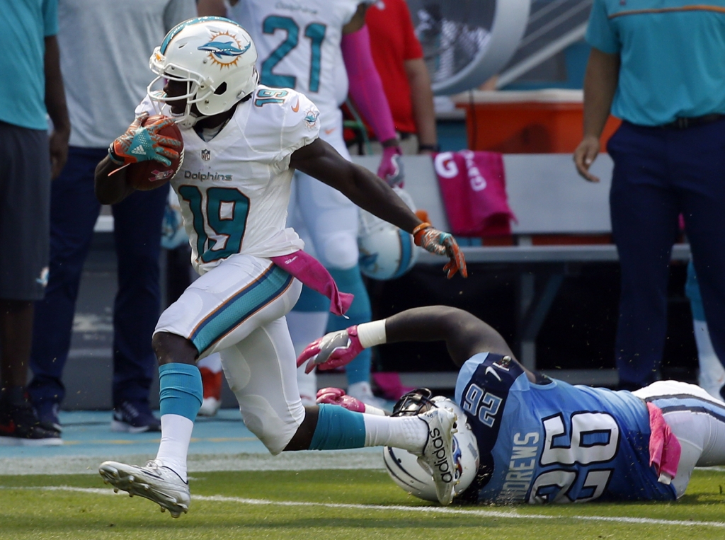 Miami Dolphins wide receiver Jakeem Grant runs for a touchdown ahead of Tennessee Titans running back Antonio Andrews, during the first half of an NFL football game Sunday Oct. 9 2016 in Miami Gardens Fla