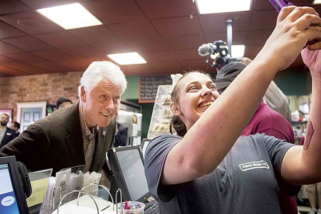 Former President Bill Clinton stops for a selfie with Ashley Neader 26 of Marietta Tuesday during his visit to Third Street Deli